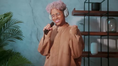 Jovem mulher fingindo cantar enquanto ouve música com os olhos fechados