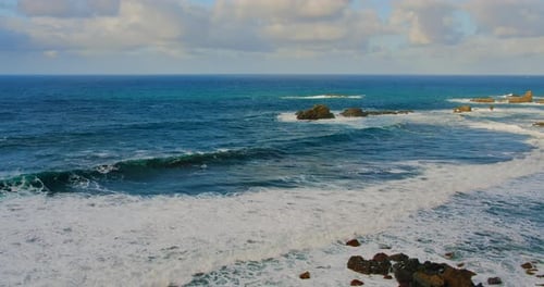 Colorful Sea Beach Waves Foaming and Splashing on the Rocky Shoreline