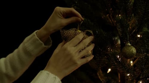 Decorating Christmas Tree With Gold Ornament
