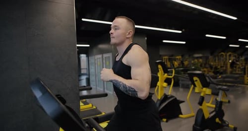 Athletic Man Running on a Treadmill in Gym Slow Motion