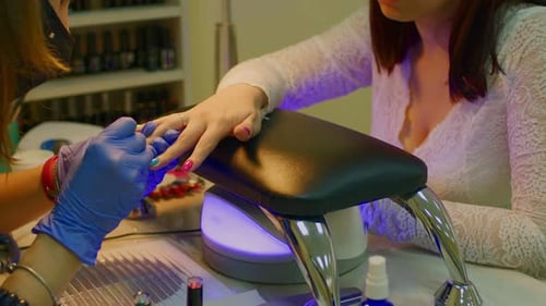 Manicurist Applying Nail Polish in Beauty Salon