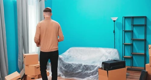 Man Unpacking Moving Boxes in Turquoise Room