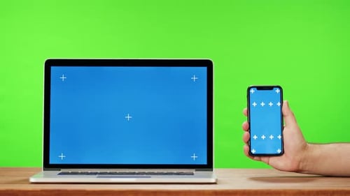 Laptop and Smartphone with Blue Chroma Key on Green Background Closeup