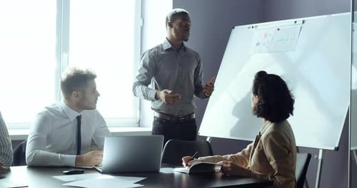 African Business Man Team Leader Presenting Project Strategy Showing Ideas on Whiteboard in Office