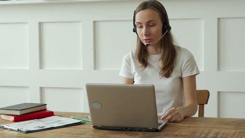 Female Operator Working with Headset and Laptop in Call Center