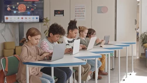 Students Learning with Laptops in Bright Classroom