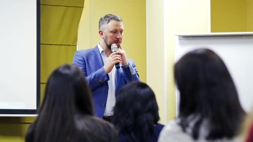 Speaker on the podium. People at the conference hall. Rear view