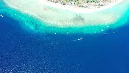 Vibrant aqua and blue waters glistening from the sunlight off the coastline of a paradise island