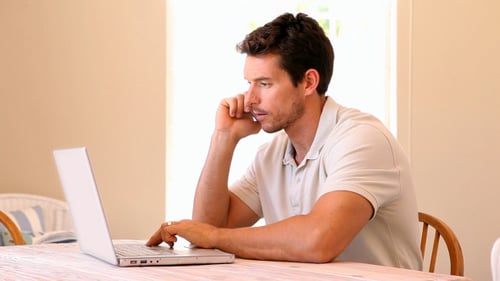 Man Talking on Phone While Using Laptop