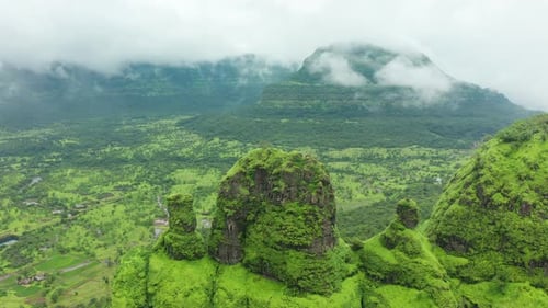Over a peak as the clouds pass by on a monsoon afternoon over the rich green surroundings