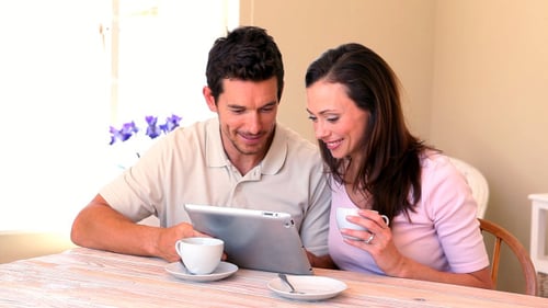 Couple Drinking Coffee and Looking at Tablet