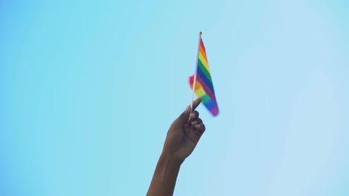 Rainbow Pride Flag Waving Against Blue Sky