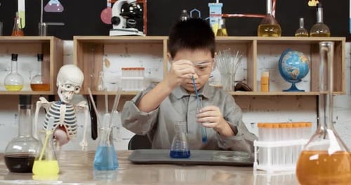Child Scientist Mixing Colorful Liquid Chemicals in Beakers