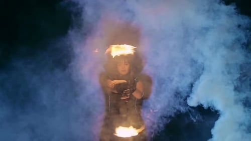 Woman with Fire Batons Performing in Smoke