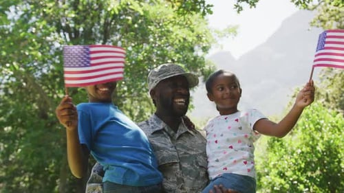 Happy Military Family with American Flags in Park