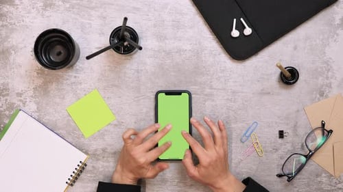 Smartphone with chroma key green screen on table