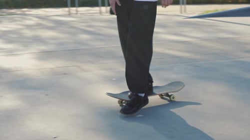 Closeup of Skateboarder's Legs in Concrete Skatepark on Autumn Day