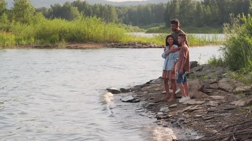 Family Standing on Lake Shore