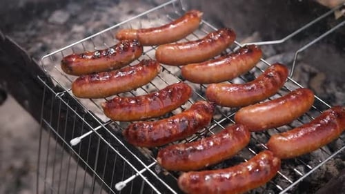 Closeup View of Tasty Sausages Grilling on Charcoal Grill Grate