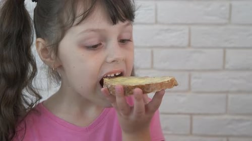 Girl Eating Bread With Buttered Toast Close-Up