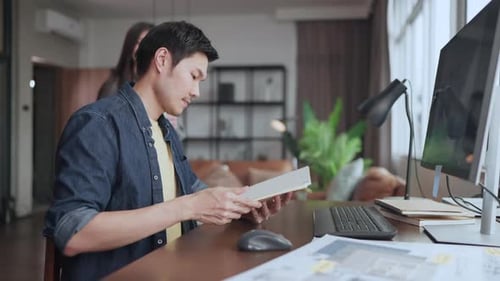 Young Adult Couple Working at Home on Computer