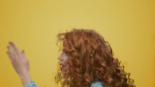 Woman Making Dance on Yellow Background. Positive Girl Dancing in Studio