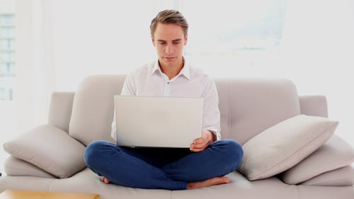 Adult Working on Laptop While Sitting on Couch