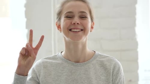 Woman Smiling and Making a Peace Sign