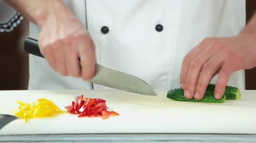 Chef Slices Cucumber on Cutting Board