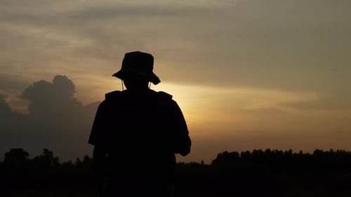 Silhouetted Figure Taking Selfie at Scenic Sunset