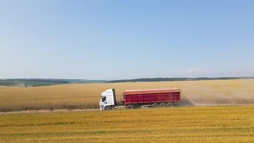Aerial View of Lorry Cargo Truck Driving on Dirt Road Between Agricultural Wheat Fields