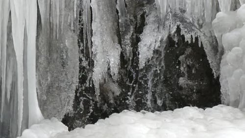 Icy Waterfall with Dripping Icicles and Snow