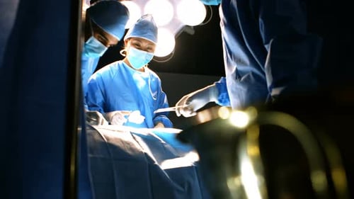 Surgeons Performing Operation Under Bright Lights