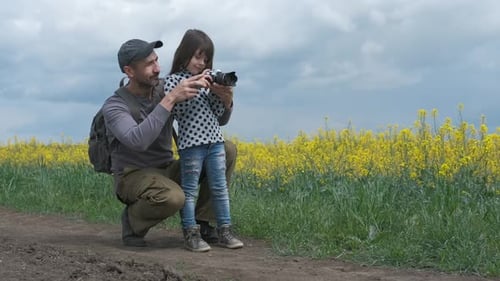 Father and Daughter Photographing in Wildflower Field
