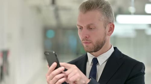 Businessman Using Mobile Phone in the Office