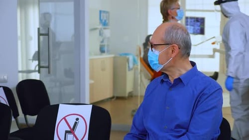 Senior Man Waiting in Mask in Medical Office