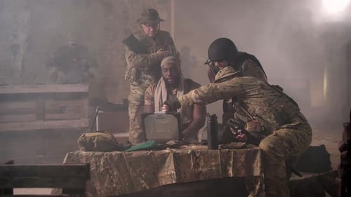 Squad of Soldiers Working on Laptop at Smoky Base