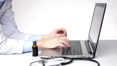 Doctor Typing on Laptop with Medicine and Stethoscope