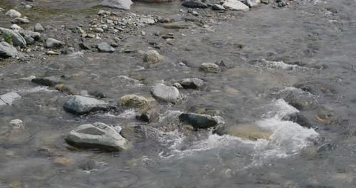 Flujo del río sobre la piedra de guijarros