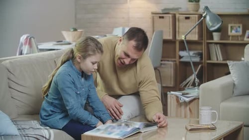 Father Reading With Daughter at Home