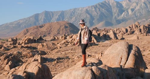 Happy Smiling Woman in Hat Is Enjoying a Sunny Sunrise in Rocky Valley Nature.