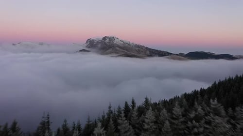 Flight Through Clouds Over The Forested Mountain At High Altitude