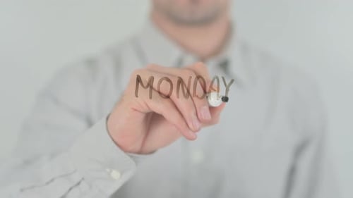 Hand Writes the Word Monday on Glass