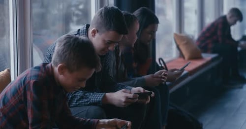 Students Using Smartphone in School Corridor