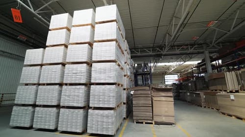 packed pallets of a parquet board stand in the warehouse at a woodworking plant.