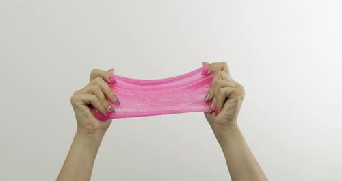 Woman Hands Playing Oddly Satisfying Pink Slime on White Background. Antistress