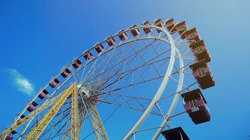Giant Ferris Wheel Spinning Under Blue Sky