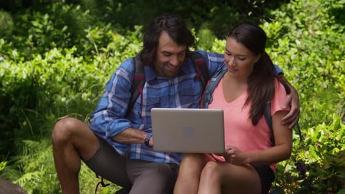Couple in Forest Using Laptop Computer