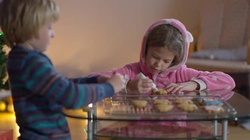 Children Decorating Cookies in Cozy Home at Christmas