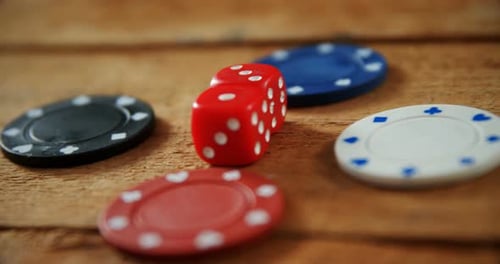 Fichas y dados de casino sobre mesa de madera en casino 4k
